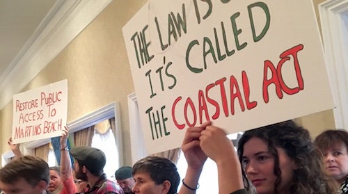 Protesters holding signs. The most visible one reads "Restore public access to Martins beach"