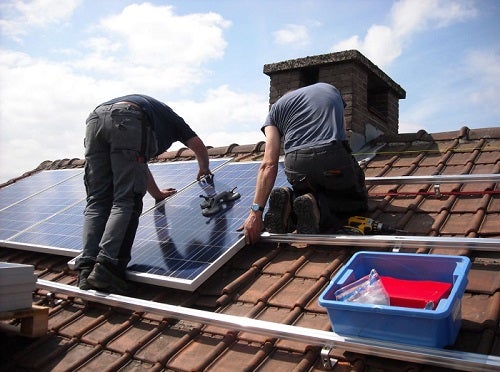 Two people installing solar panels