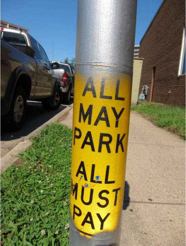 A sign on a parking meter in Arlington that says "ALL MAY PARK ALL MUST PAY"