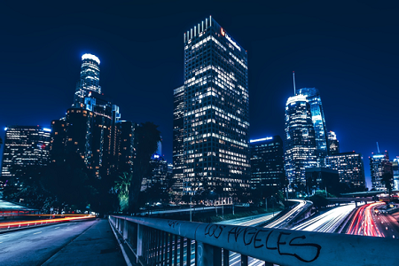 A long exposure photo taken from a Los Angeles bridge, with a view of buildings and car lights on a freeway