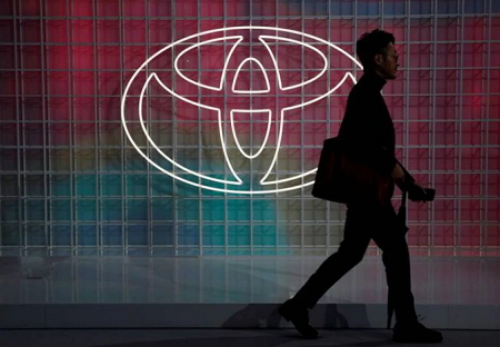 A man walks past a Toyota logo at the Tokyo Motor Show in Tokyo.