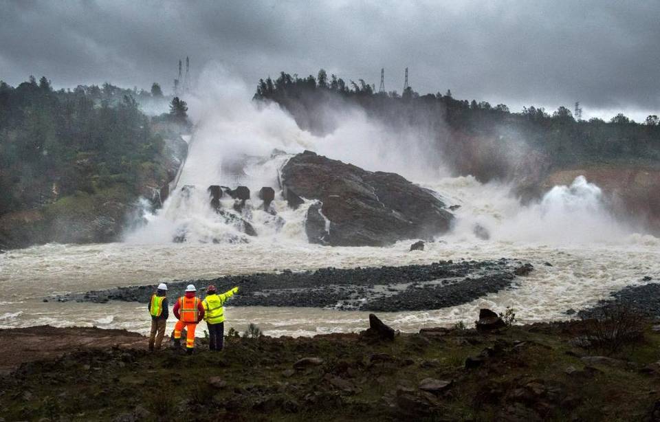 3 people looking at the Oroville Dam.