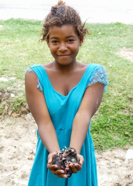 Girl holding baby opossums.