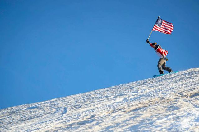 A skier holding an American flag.