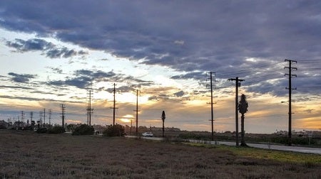 a sunset with view of utility poles