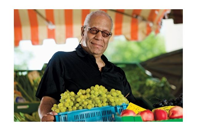 Man carrying a crate of grapes.