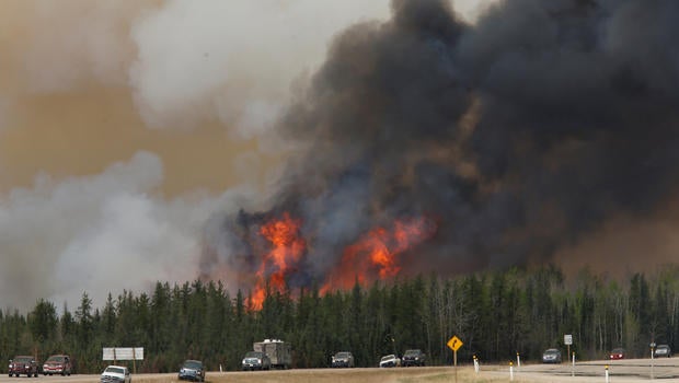 A wildfire burns as evacuees who were stranded north of Fort McMurray, Alberta, Canada head south of Fort McMurray on Highway 63, May 6, 2016.
