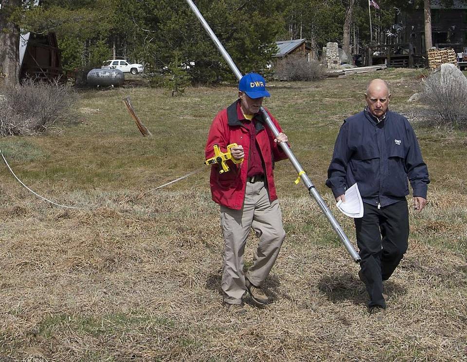 Gov. Jerry Brown, right, walks into a snowless meadow during the 2015 snowpack survey. 