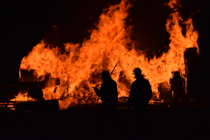 fire fighters in front of the Glen MacDonald fire in Australia at night