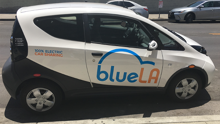 Car with "100% electric car sharing" and "BlueLA" printed on sides