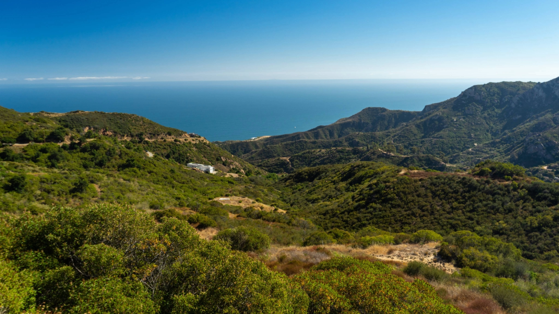 An ocean view from green mountains