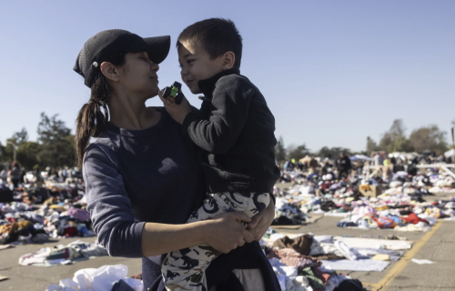 A woman carries a small child