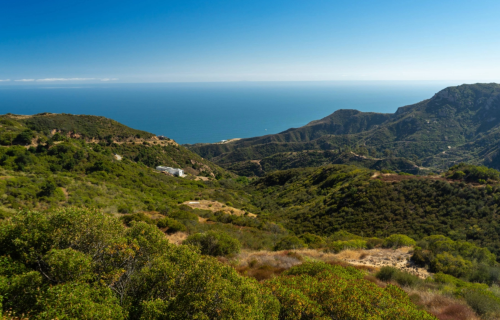 An ocean view from green mountains