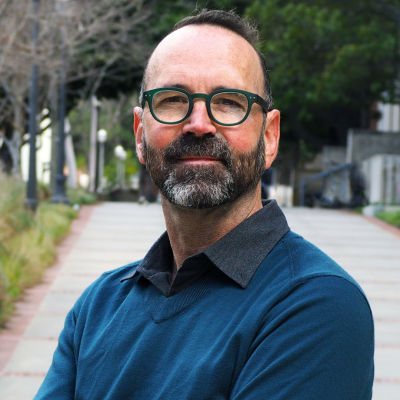 A man wearing glasses looking straight ahead.