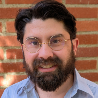 A man with glasses smiling at the camera