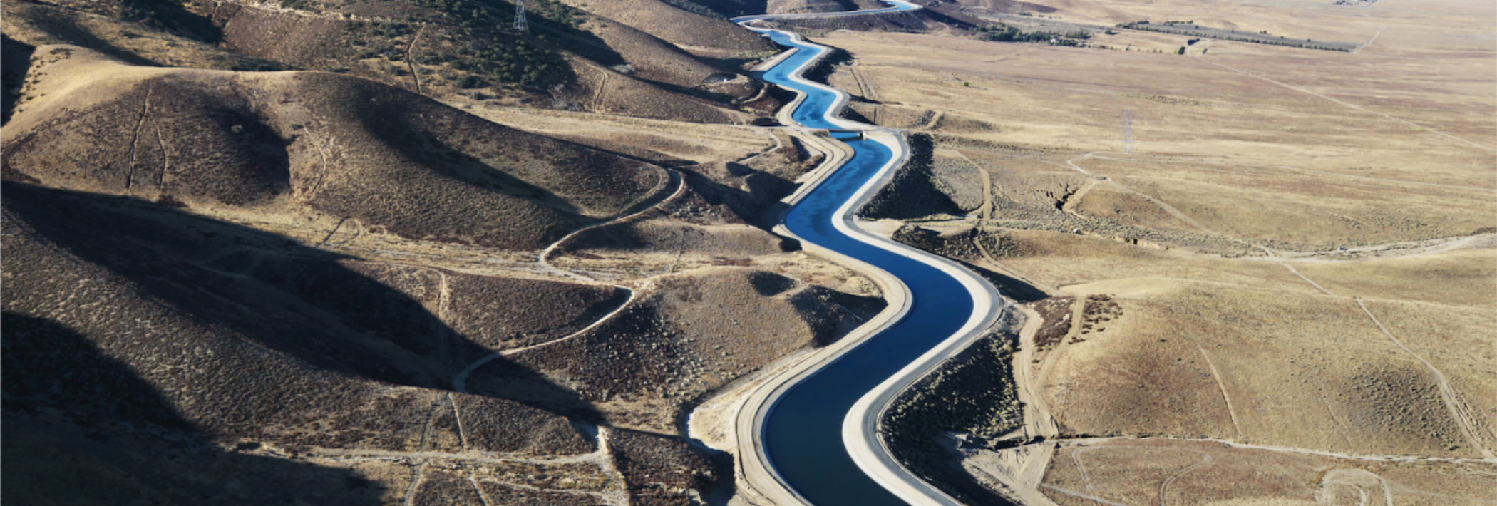 An overhead view of an aqueduct in the desert.