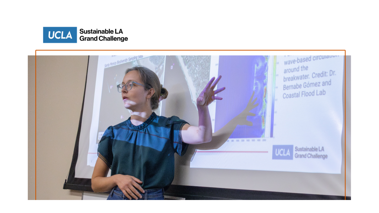 A young woman gestures at a slide projected behind her.