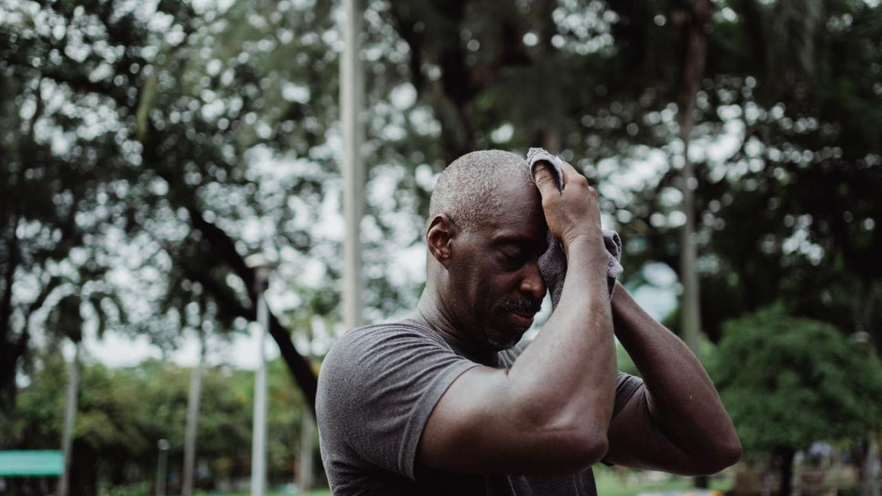 Man wiping off his eyebrow in the heat