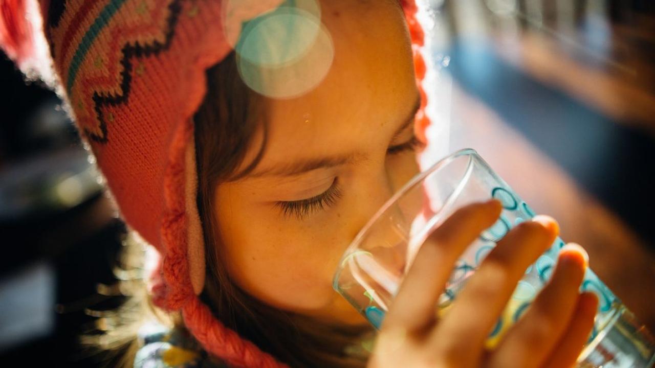 A child drinking from a cup of water