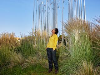 Marilyn Raphael in front of the Weather Field No. 1, a dynamic sculpture that shifts with the air at Tongva Park in Santa Monica. Like Raphael's work, the sculpture reminds us of our connection to both local and global climate conditions.